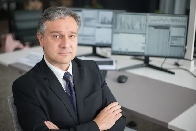 Business executive in office focused on financial analysis with computer monitors. Jak działa system ERP w średniej firmie: funkcje, moduły i kryteria wyboru