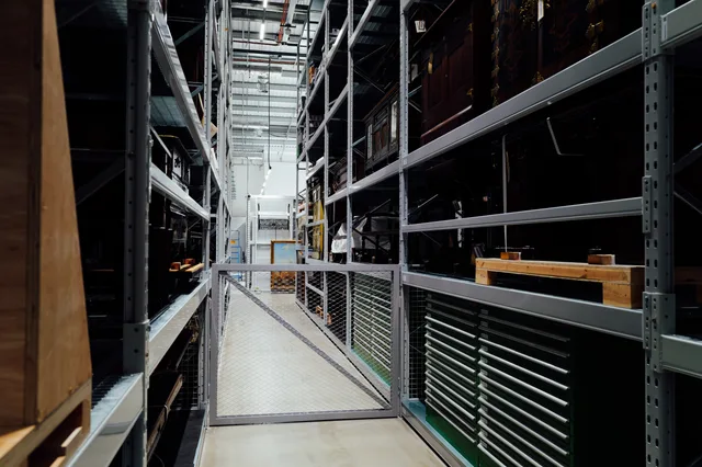 A detailed look at the interior of an industrial storage warehouse with metal shelves. Moduły magazynowe w ERP: funkcje do sprawdzenia przed wyborem